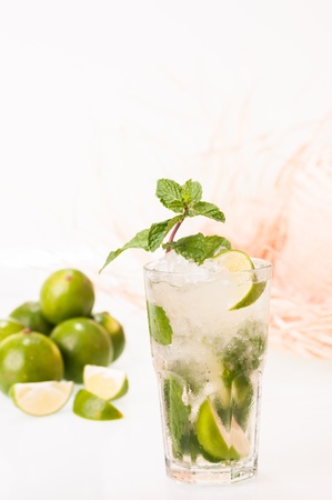 Mojito cocktail with fresh limes and straw hat at the background の写真素材
