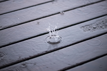 Splashing rain water drops on wooden deck close upの写真素材