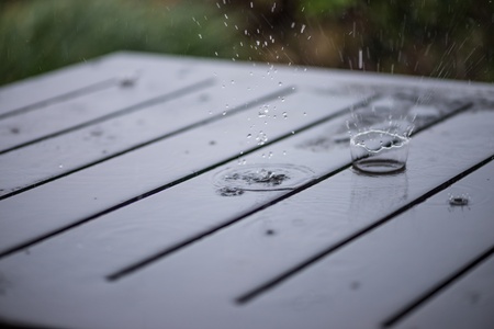 Splashing rain water droplets on wooden deck in the garden の写真素材