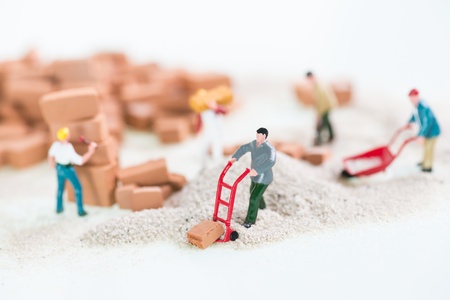 Miniature workmen doing construction brickwork close up の写真素材