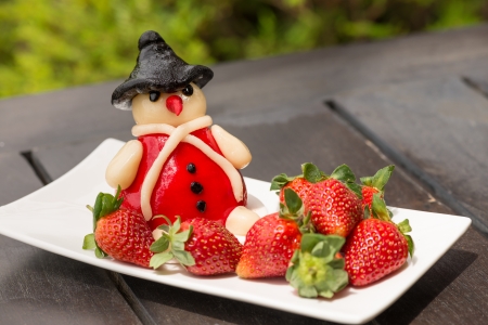 Fresh strawberries and marzipan on an outdoor rustic wooden table close-upの写真素材