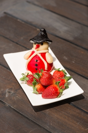 Fresh strawberries and marzipan on a rustic wooden table close-upの写真素材