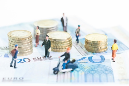 Miniature people on 20 Euro banknotes and coins close-upの写真素材