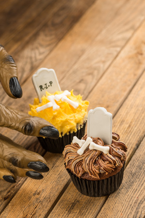 Werewolf hand reaching for a Halloween cupcake top view の写真素材