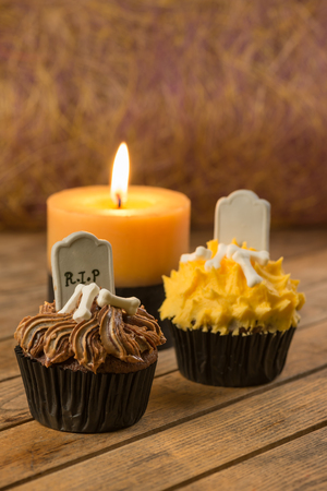 Spooky Halloween cupcakes and a burning candle close-upの写真素材