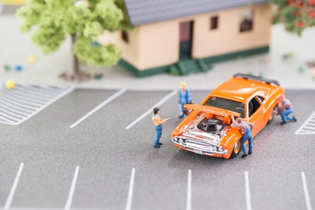 Miniature mechanics working on a car の写真素材