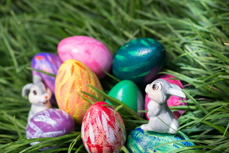 A ray of sunlight shines onto the Easter bunny on an egg の写真素材