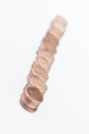 Stacked pennies in a row over white background の写真素材