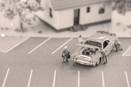 Miniature mechanics working on a car in black and white の写真素材