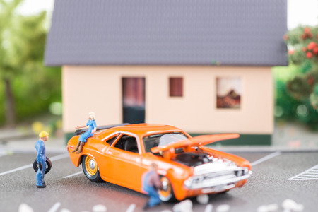 Miniature mechanics replacing a punctured tyre of a car の写真素材