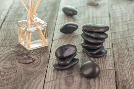 Aromatherapy sticks and black stones on weathered deck backgroundの写真素材