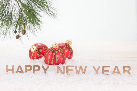 Red Christmas baubles and  Happy New Year wishesの写真素材