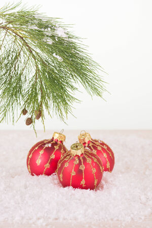Red Christmas baubles in snowflakes and pine tree branchの写真素材