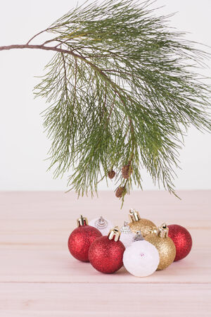 Pine tree branch with red, whte and gold Christmas baubles close-upの写真素材