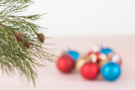 Pine tree branch with red, blue and gold Christmas baubles backgroundの写真素材
