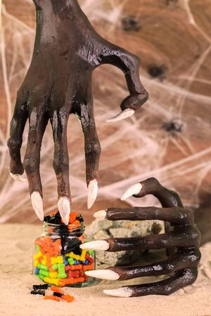 Halloween witch hands and colorful candiesの写真素材
