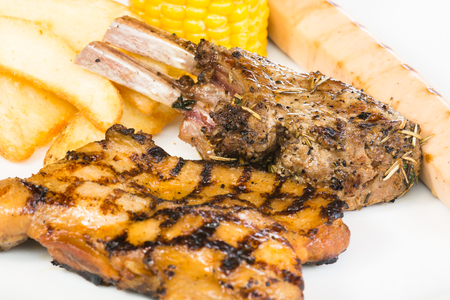 Grilled meat platter with chicken thigh, wedges, lamb racks and chicken sausageの写真素材