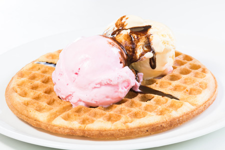 Vanilla and strawberry ice cream on a waffle and glazed with belgian chocolate sauceの写真素材
