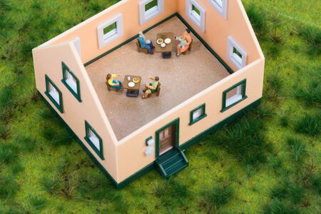 Miniature people having their dinner in a restaurantの写真素材