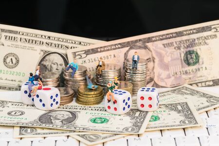 Online gambling concept with miniature people and coinsの写真素材