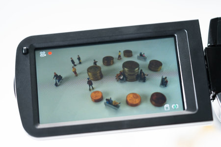 Miniature people being monitored on cameraの写真素材