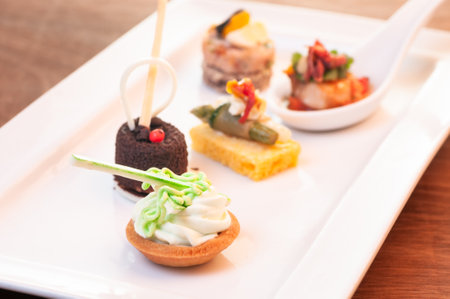 Petit fours and scallop Amuse Bouche on white plateの写真素材