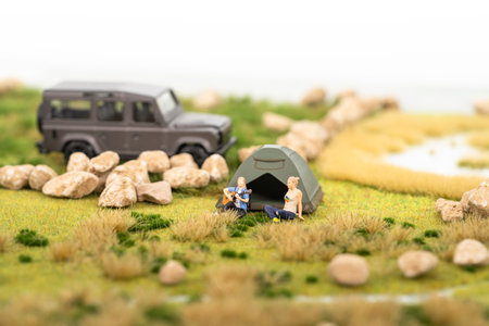 Miniature man playing guitar with his friend at campsiteの写真素材