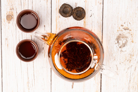 Chinese puerh tea in glass pot and clay cups with puerh tea bricks top viewの写真素材
