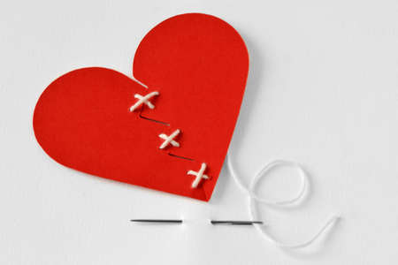 Paper broken heart sewn with needle and thread - Love troubles conceptの写真素材
