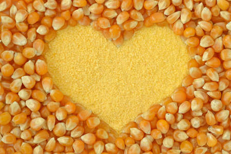 Maize flour heart with corn kernels backgroundの写真素材