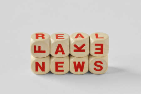 Words Fake and Real News written with wood cubesの写真素材