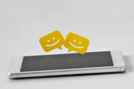 Smartphone with chat message bubbles on white backgroundの写真素材