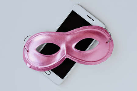 Pink mask on mobile phone - Concept of privacy, security and anonymity of mobile phone for womenの写真素材