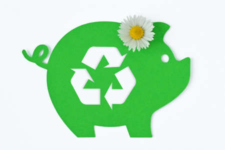 Paper green piggy bank with recycling symbol and daisy flower on white background - Concept of saving money, ecology and recyclingの写真素材