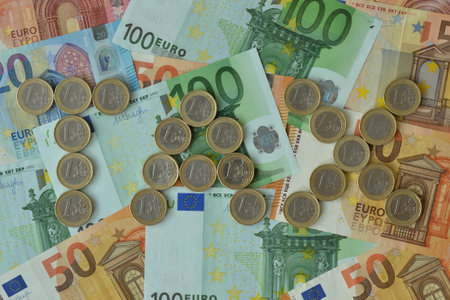 The word Tax written with euro coins on euro banknotes background