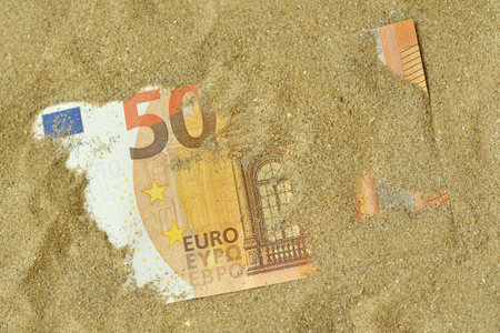 Euro banknote covered by sand - Concept of finance and businessの写真素材