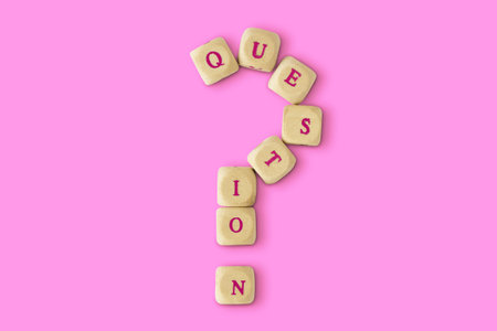 Question mark made of wooden letter blocks on pink background - Concept of listening and support to womenの写真素材