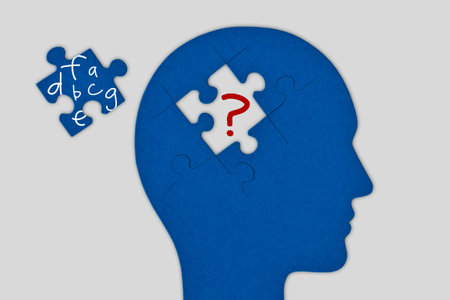 Head profile with brain made of jigsaw puzzle pieces on white background - Concept of dyslexia and...