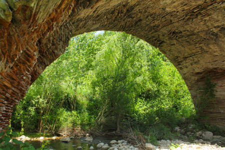 An arch of the Chianche Bridge in Buonalbergo Campania Italy. The bridge is part of Trajan's Road built with stone slabs in the second century AD on orders of the emperor. It spans a small tributary of the Miscano River.の写真素材
