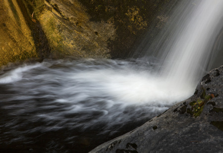 Side view of the silky water of an upper cascade and plunge pool at Kent Falls State Park in western Connecticut.の写真素材