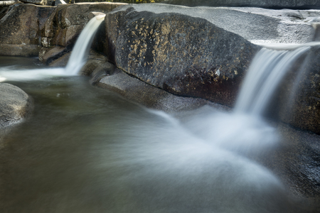 Long exposure of double waterfall over granite ledge  into clear pool at Diana's Baths near North Conway, New Hampshire.の写真素材