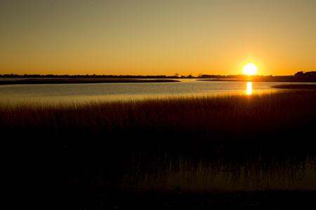Golden sunset over the marsh at the Milford Point Coastal Center of the Connecticut Audubon Society.の写真素材
