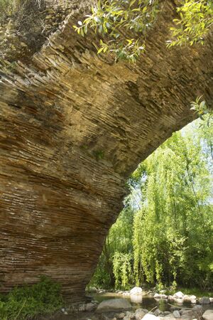 Arch of the Chianche Bridge in Buonalbergo, Campania, Italy. The bridge is part of Trajan's Road, built with stone slabs in the second century AD on orders of the emperor. It spans a small tributary of the Miscano River.の写真素材
