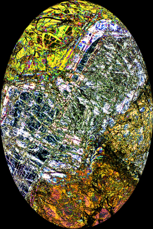 Bands of colorful patterns in abstract, egg-shaped micrograph of peridotite rock at 40x.の写真素材