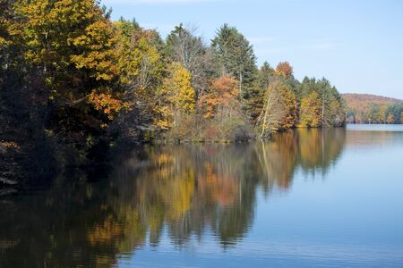 Colorful autumn shoreline of a West Hartford Reservoir in Connecticut.の写真素材