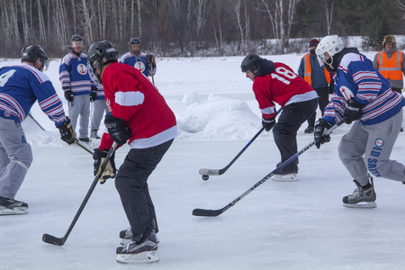 Men's teams compete on the ice at the 11th annual New England Pond Hockey Festival on Hayley Pond in Rangeley, Maine.のeditorial素材