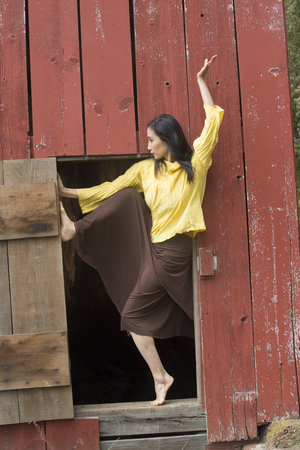 Shapes of a dancer complement a doorway in the side of a red barn on a farm in Ellington, Connecticut.の写真素材