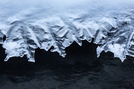 Frills in the edges of overhanging ice along the Blackledge River in Glastonbury, Connecticut.の写真素材