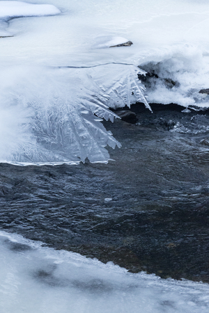 Frills in the edges of overhanging ice along the Blackledge River in Glastonbury, Connecticut.の写真素材