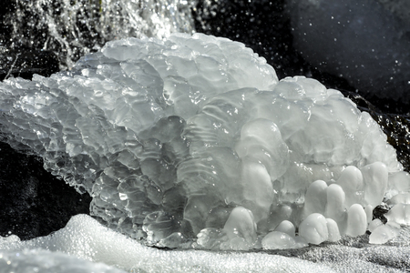 Bubbly mound of ice in the waterfall of Railroad Brook at Valley Falls Park in Vernon, Connecticut in winter.の写真素材